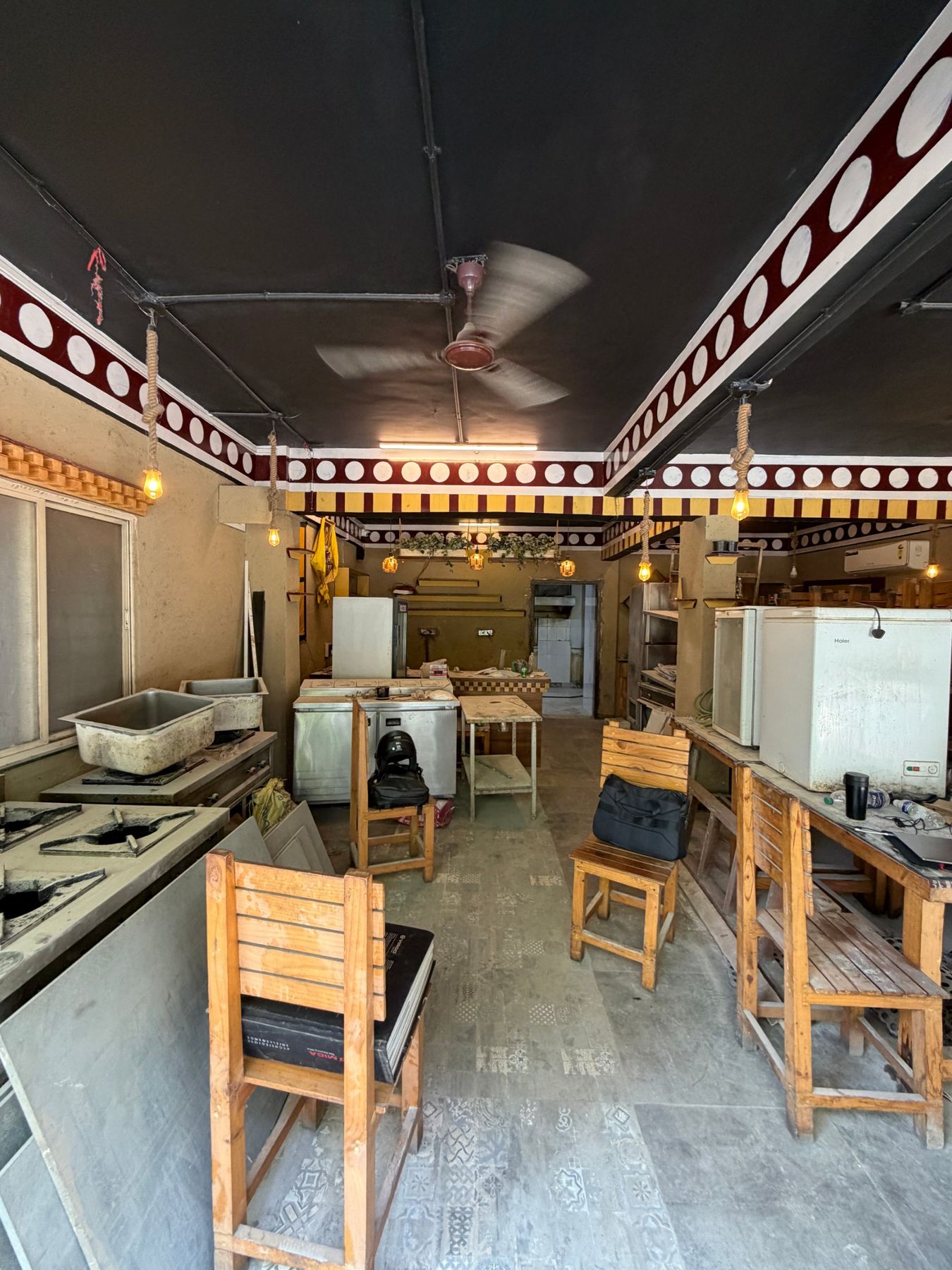 The restaurant before refurbishment: dark ceiling, bare bulbs, kitchen equipment in the dining room