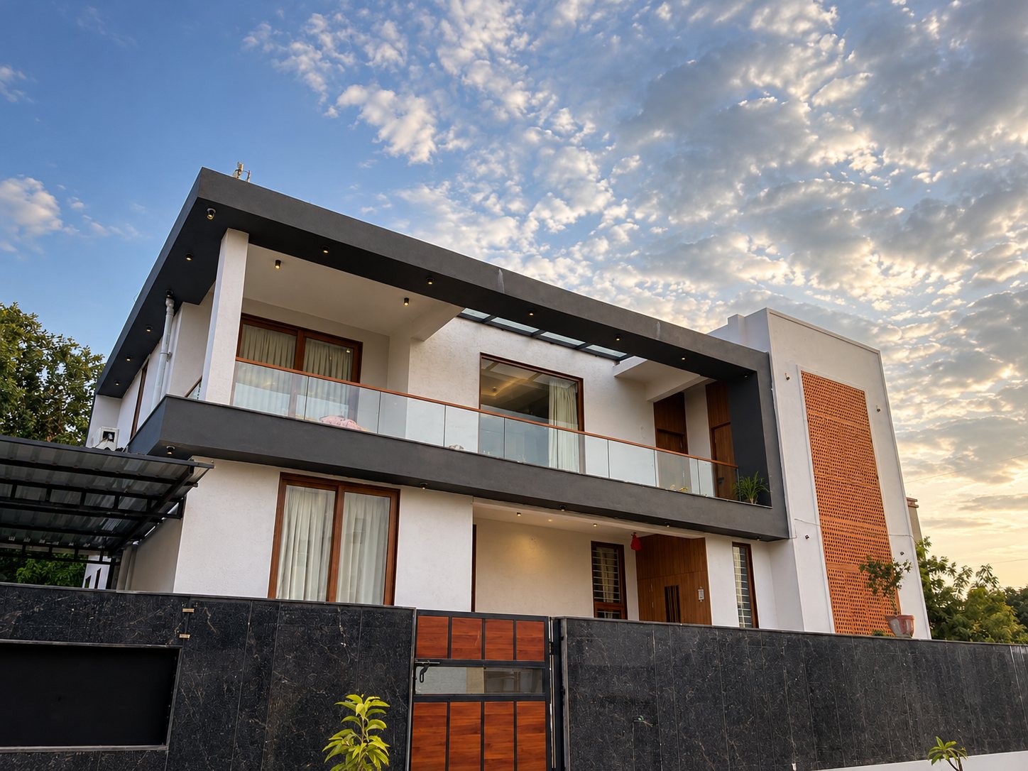 Two-storey house at dusk with a terracotta jaali screen, completed project